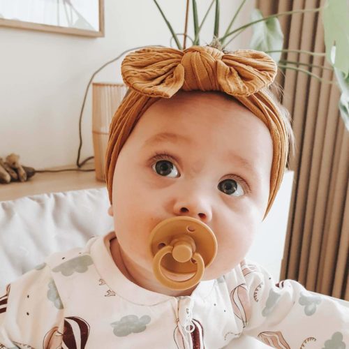 bebis med senapsfärgat hårband